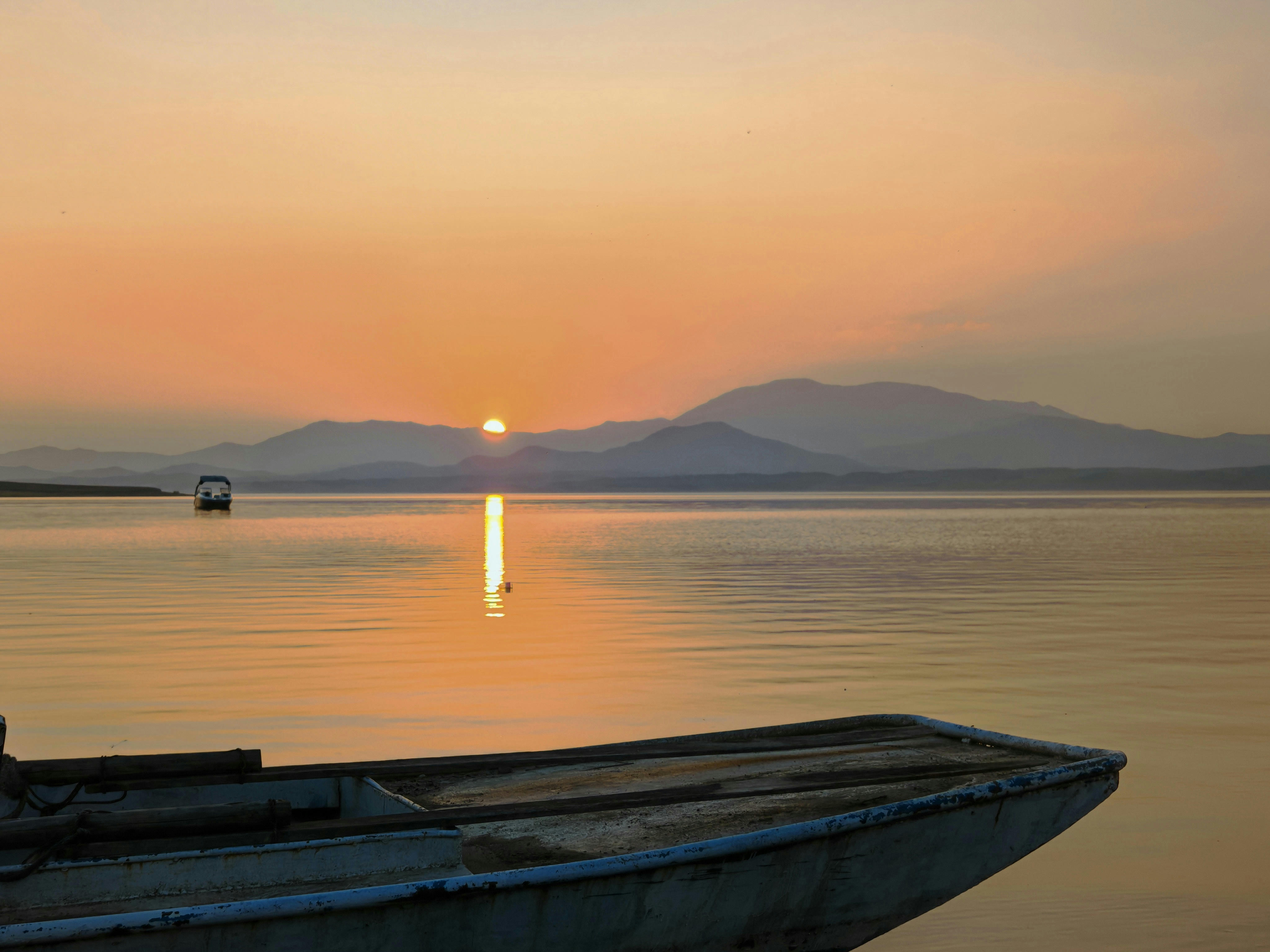 Sunset over Songhua Lake, with blue silhouettes of distant mountains. October 2025.